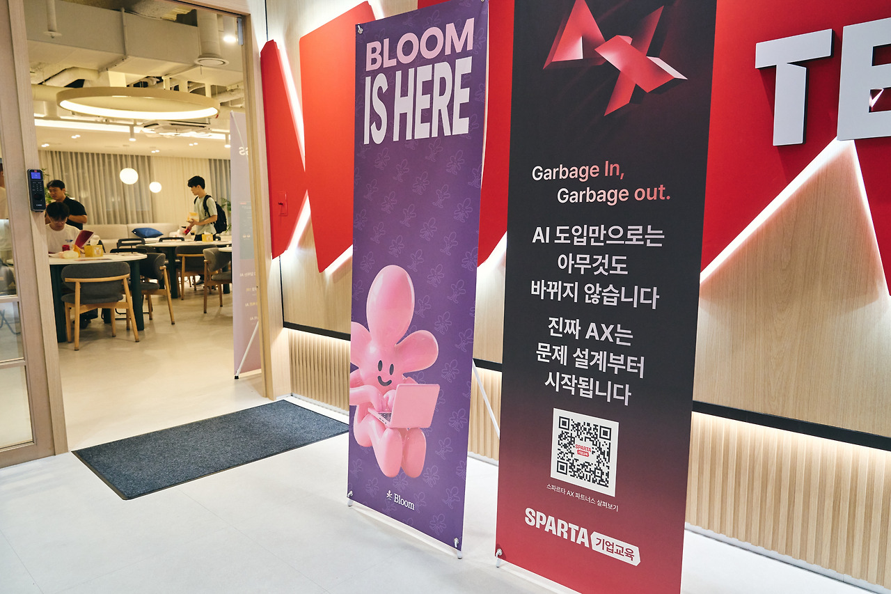 입구에 세운 「BLOOM IS HERE」 배너와 「Garbage In, Garbage out」 배너