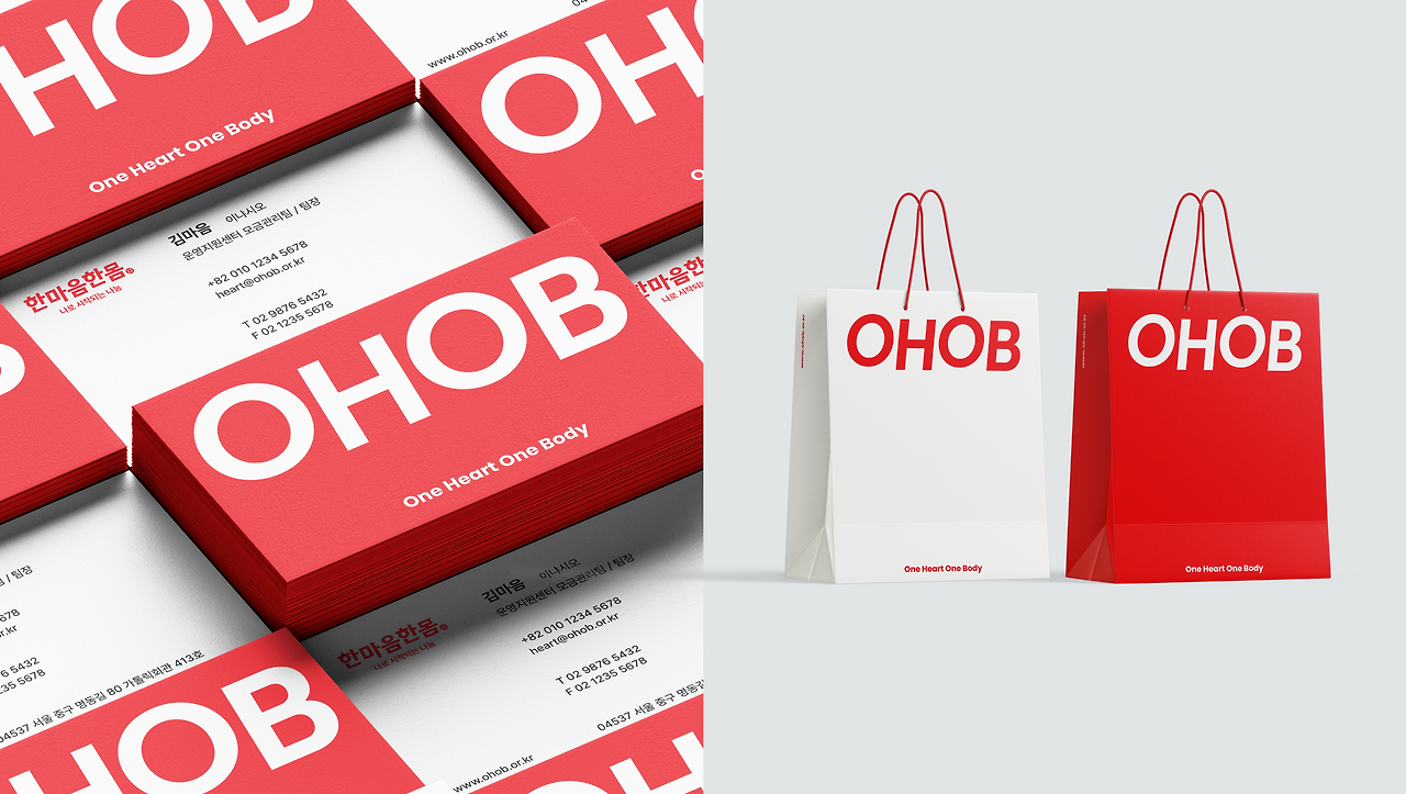 한마음한몸 로고와 슬로건이 인쇄된 빨간색 브랜드 명함 더미와 한마음한몸 로고가 인쇄된 흰색과 빨간색 쇼핑백 두 개